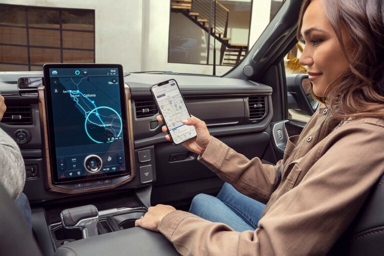 Woman passenger connecting her smartphone to the interior touchscreen of a 2022 F-150 Lightning.