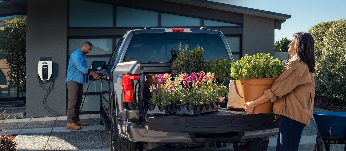 A man plugs his F-150® Lightning™ into a Ford Charge Station Pro