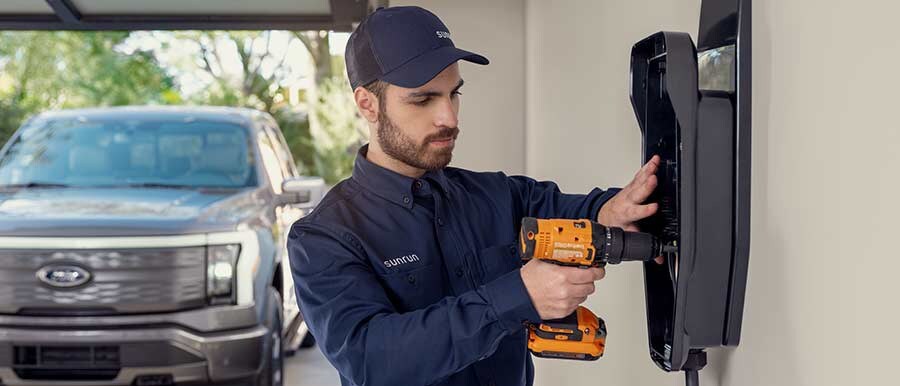 Un técnico de Sunrun instalando una estación de carga para vehículos eléctricos