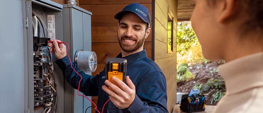 Un electricista trabaja en la caja de electricidad de una vivienda