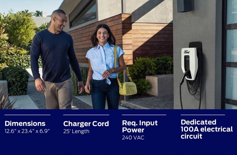 A couple walks by their Ford Charge Station Pro