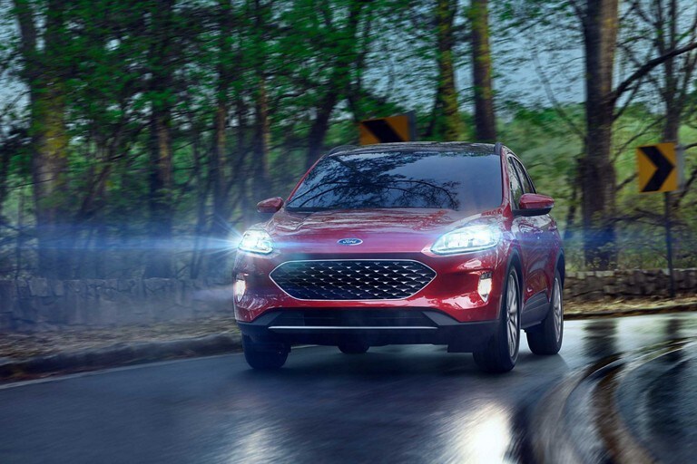 A 2020 Ford Escape being driven around a curve on a rainy day