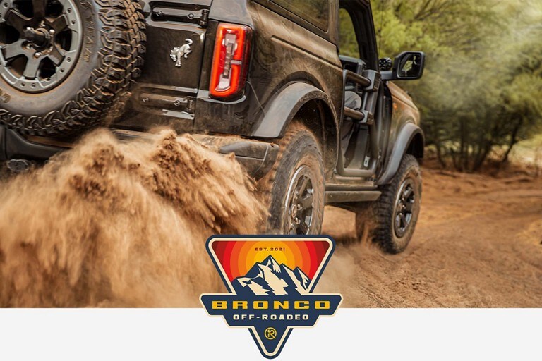 Ford Bronco® Off-Roadeo Logo with a 2023 Ford Bronco® model being driven over a rough trail