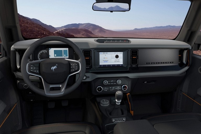 Interior de la Ford Bronco® 2023 con volante forrado de cuero disponible con insignia de Bronco® y controles de velocidad y sonido