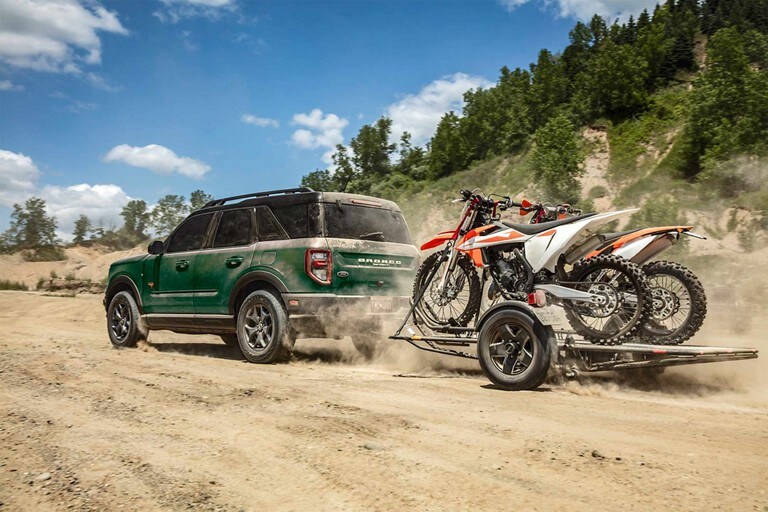 Una Ford Bronco® Sport 2023 remolcando un tráiler en una duna de arena