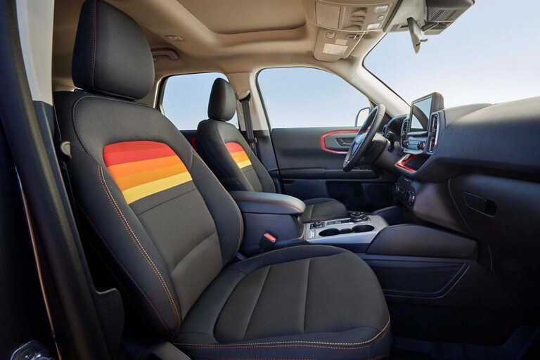 Se muestran los asientos de una Ford Bronco® Sport Free Wheeling™ 2024 con franjas arco iris en los respaldos de los asientos