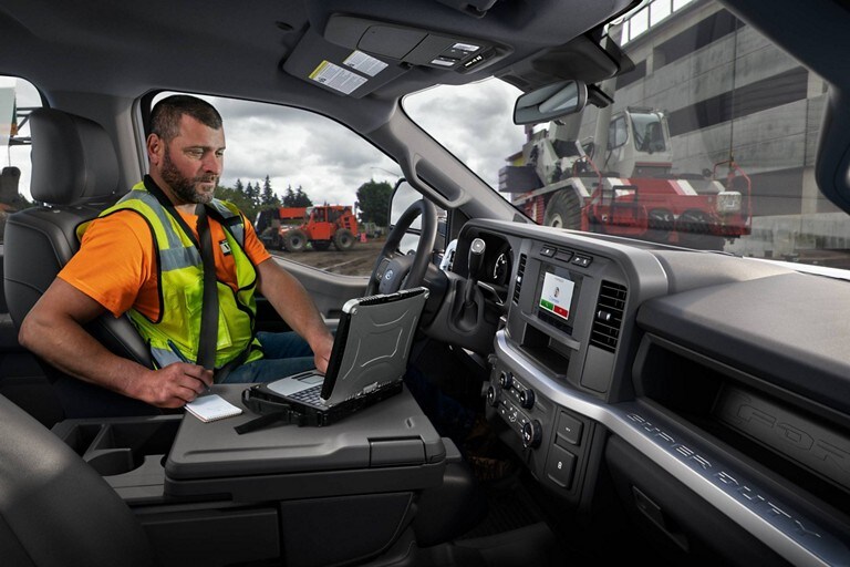 Trabajador usando una laptop dentro de una Ford con Chasis con Cabina Super Duty® 2023