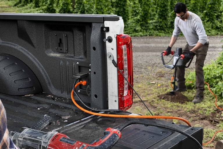 Man is using an auger while it's being charged with the Pro Power Onboard feature