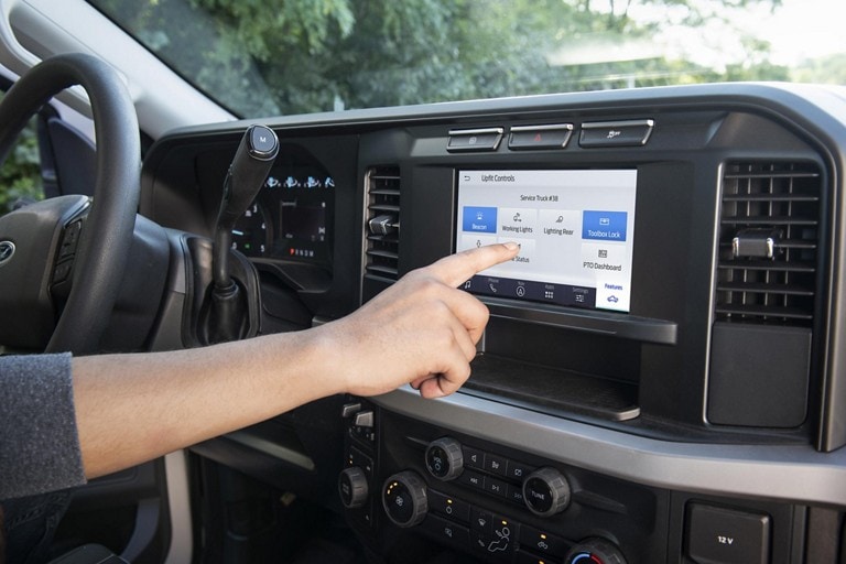Up close screen of the upfit system with a person making a selection on the screen