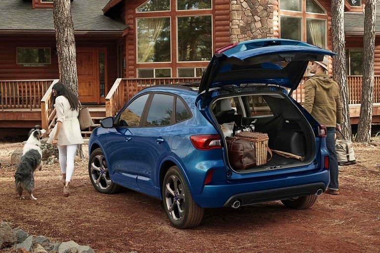 Rear shot of a 2023 Ford Escape® ST-Line in Atlas Blue with rear hatch open and luggage inside