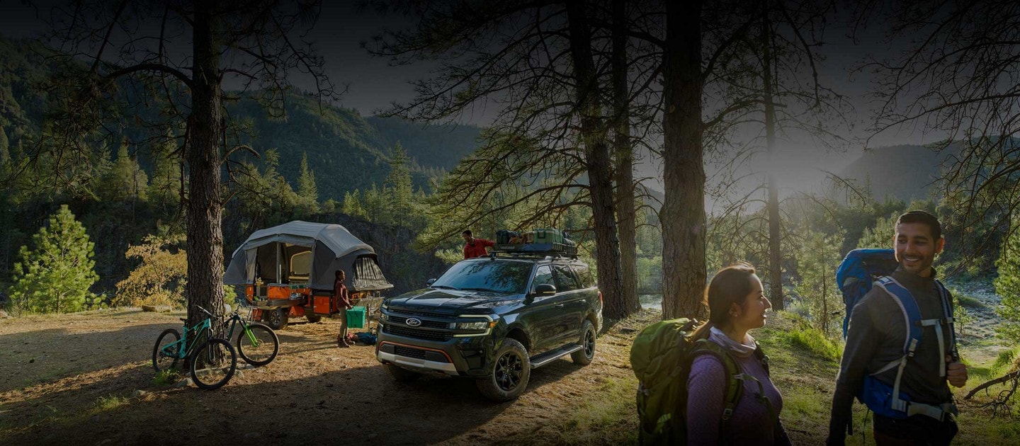 Side by side shots of a 2023 Ford Expedition SUV being driven down a dirt road and parked at a campsite