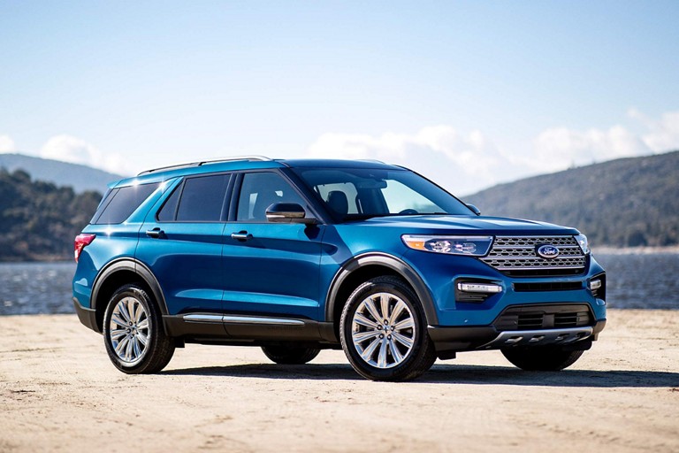 2023 Ford Explorer Limited in front of a body of water, with clear skies above