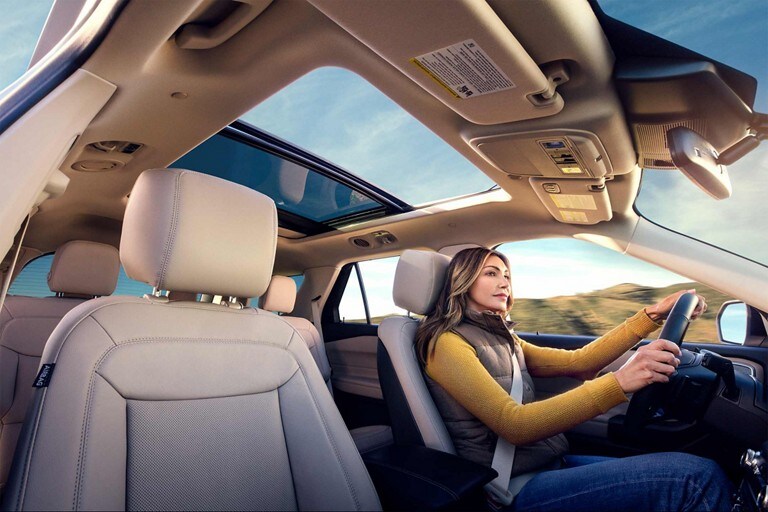 2023 Ford Explorer® SUV interior with a person driving with the twin-panel moonroof open