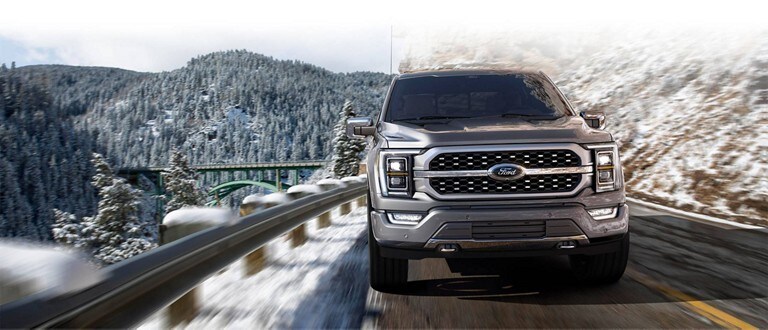 Front view of a 2023 Ford F-150® being driven on a snowy mountain roadway