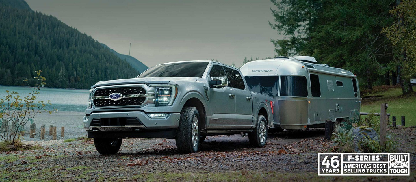 A 2023 Ford F-150® attached to a camper at a campground