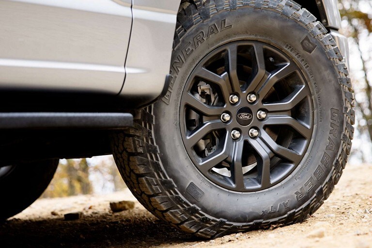Primer plano de las ruedas de aluminio de 18” con acabado Dark Matte de una Ford F-150® Tremor™ 2023