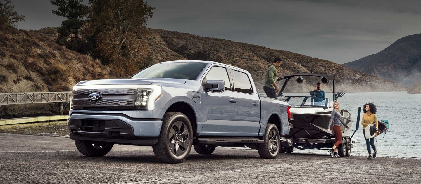 A 2023 Ford F-150® Lightning™ pulling a boat out of the water at the boat dock