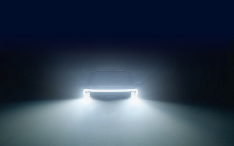 A 2023 Ford F-150 Lightning is shown in fog with headlights on