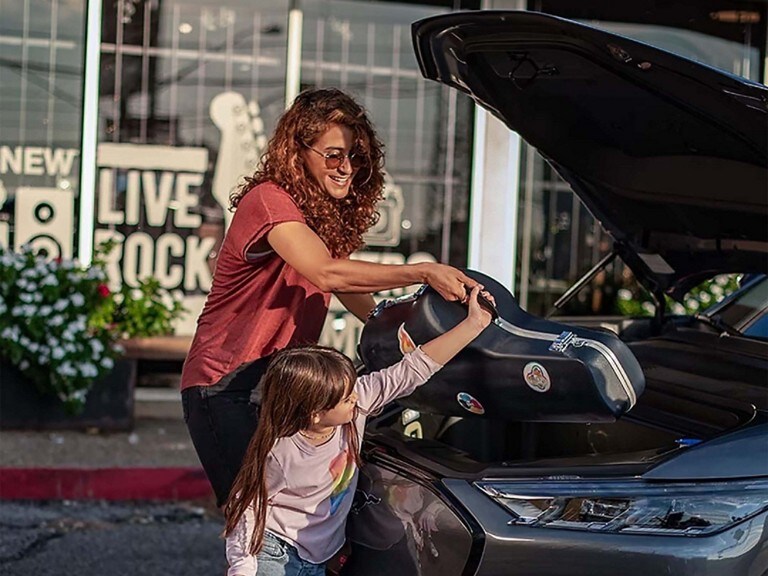 Woman and child putting instrument in 2023 Ford Mustang Mach-E Frunk