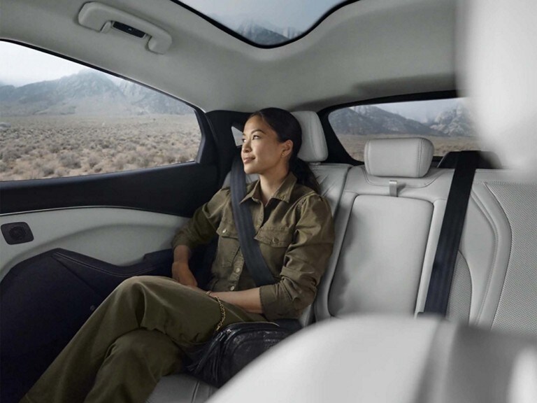 Woman sitting in rear seat of a 2023 Ford Mustang Mach-E