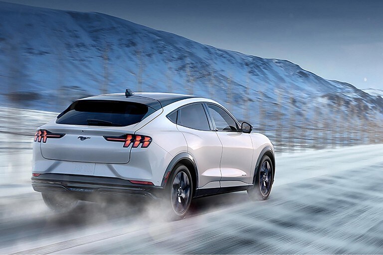 Una Ford Mustang Mach-E® 2023 circulando por una carretera en invierno