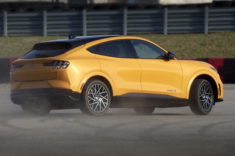 Una Ford Mustang Mach-E® 2023 andando en una pista de carrera y largando humo por los neumáticos
