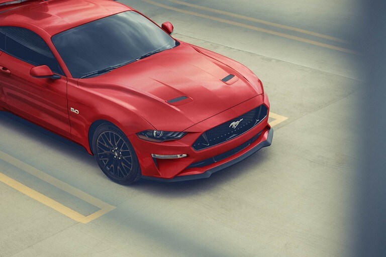 Una Ford Mustang® Coupe 2023 estacionada afuera de un garaje