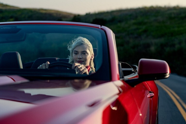 Una persona andando en un modelo Ford Mustang® 2024 convertible en una carretera