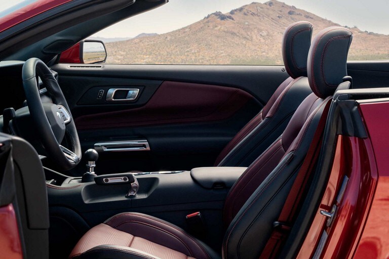 Parked 2024 Ford Mustang® convertible with the driver's side door open showing the available Carmine Red interior