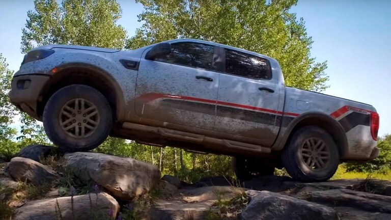 Se muestra una Ford Ranger® Tremor 2023 en Oxford white con franjas sobre unas rocas