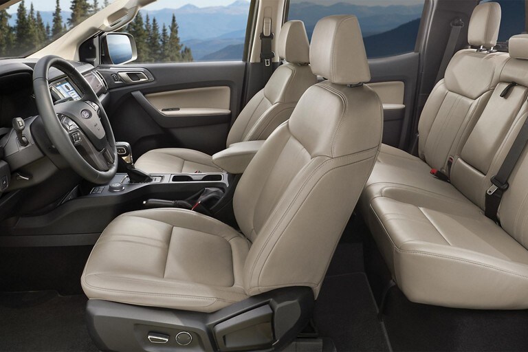 Vista interior de la Ford Ranger LARIAT 2023 que muestra asientos individuales delanteros con asientos de cuero y banco trasero con asientos tapizados en cuero