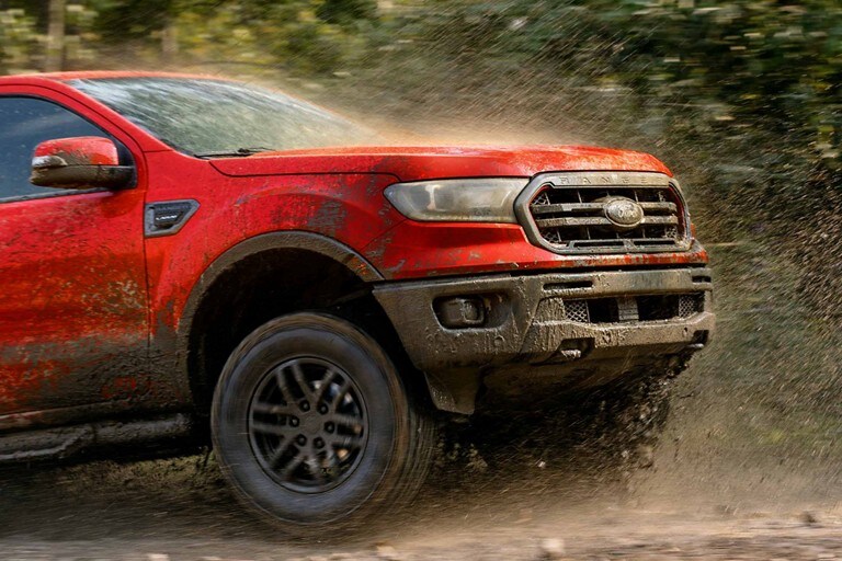 Una Ford Ranger 2023 con Paquete Tremor para Todo Terreno circulando por un camino cubierto de lodo