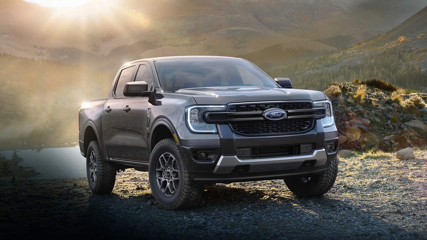 A 2024 Ford Ranger® in Carbonized Gray is parked by a lake during sunset