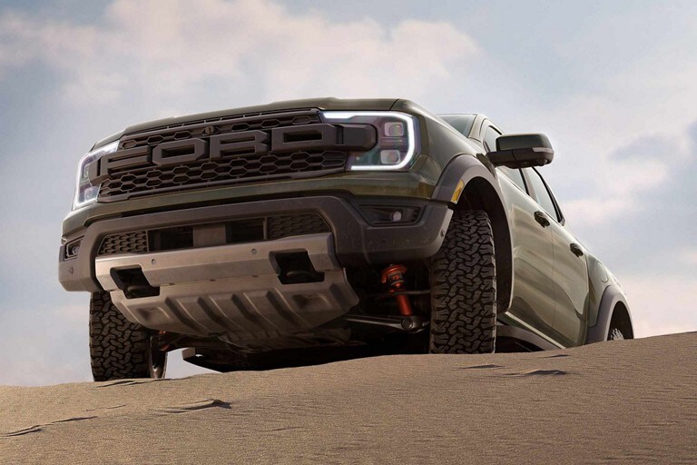 A close-up of the front bumper of a 2024 Ford Ranger® Raptor® on a desert sand dune