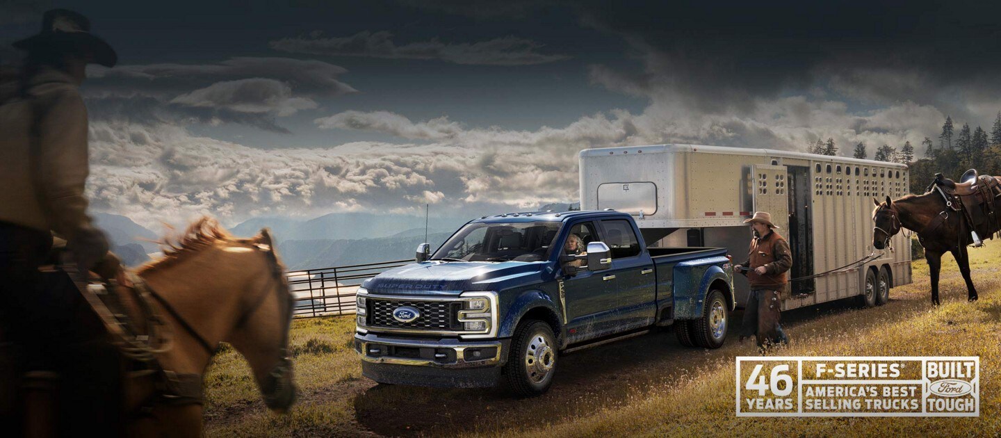 A man riding a horse toward a 2023 Ford Super Duty® F-450® King Ranch® DRW model hitched to a horse trailer