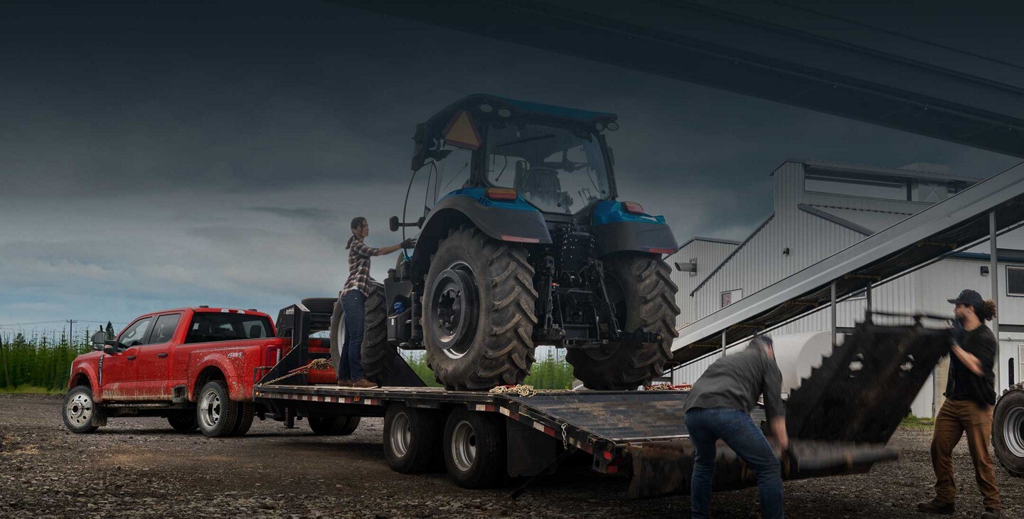 2023 Ford Super Duty® F-450® XL DRW hitched to a trailer carrying an agricultural tractor