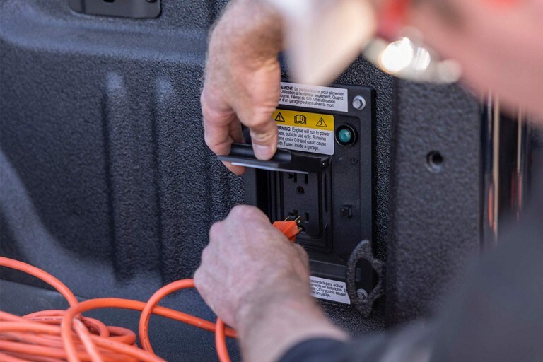 Primer plano de una persona enchufando un cable eléctrico en el sistema Pro Power Onboard