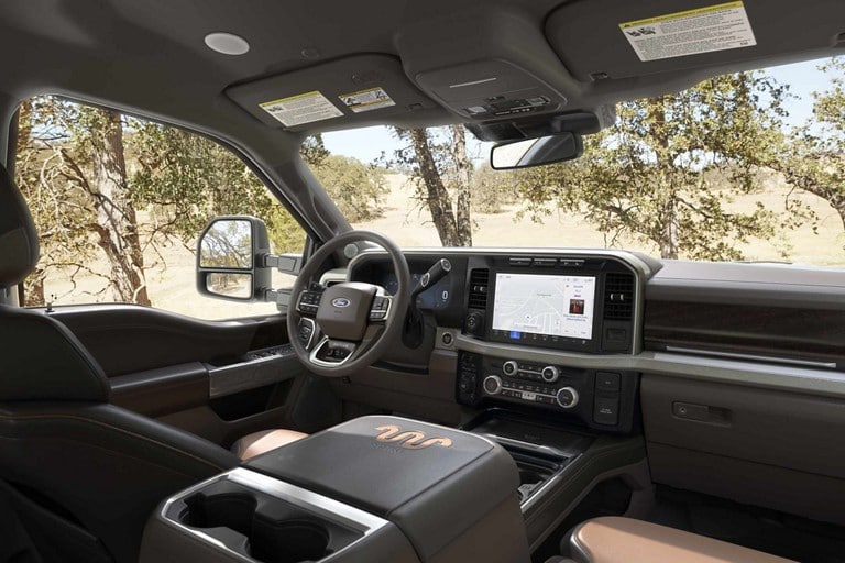 Front interior of a 2023 Ford Super Duty® King Ranch® pickup with Baja-colored leather seating surfaces