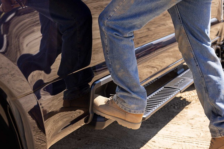 Close-up of a person using the rear bumper step and integrated box side step