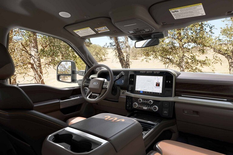 Front interior of a 2024 Ford Super Duty® King Ranch® pickup with Baja-colored leather seating surfaces
