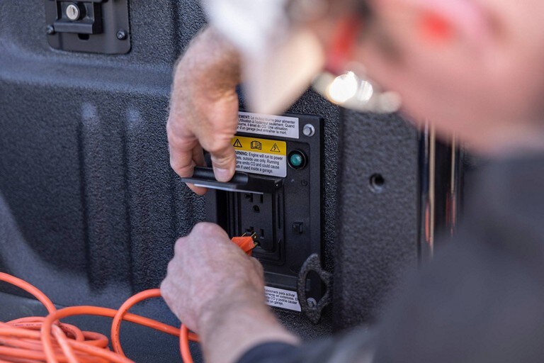 Close-up of a person plugging an electrical cord into the Pro Power Onboard system
