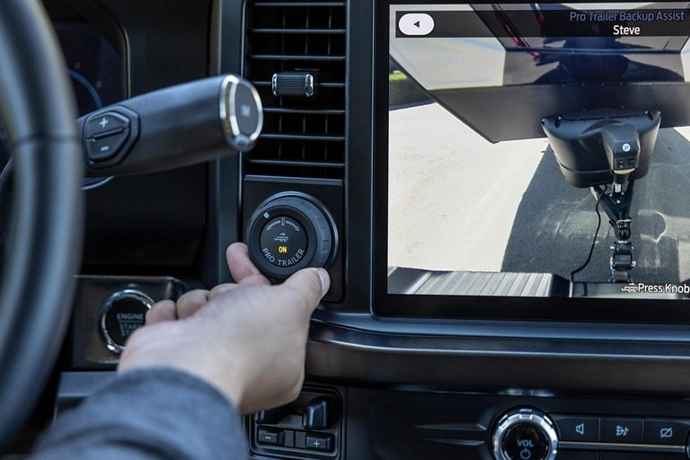 Primer plano de una persona usando la perilla Pro Trailer Backup Assist™