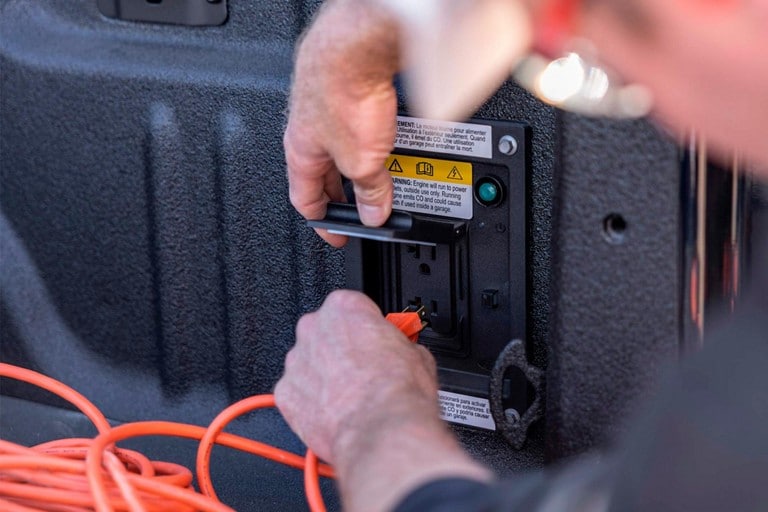 Close-up of a person plugging an electrical cord into the Pro Power Onboard system