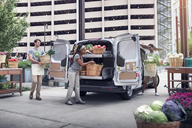 2024 White Ford Transit Connect being loaded with fresh vegetables and fruit