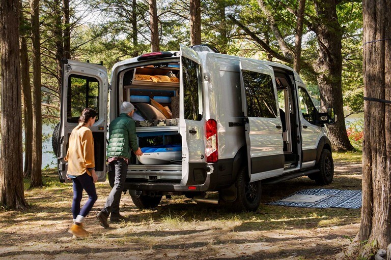 Una pareja descargando equipos de la parte trasera de una van Ford Transit Trail™ 2023