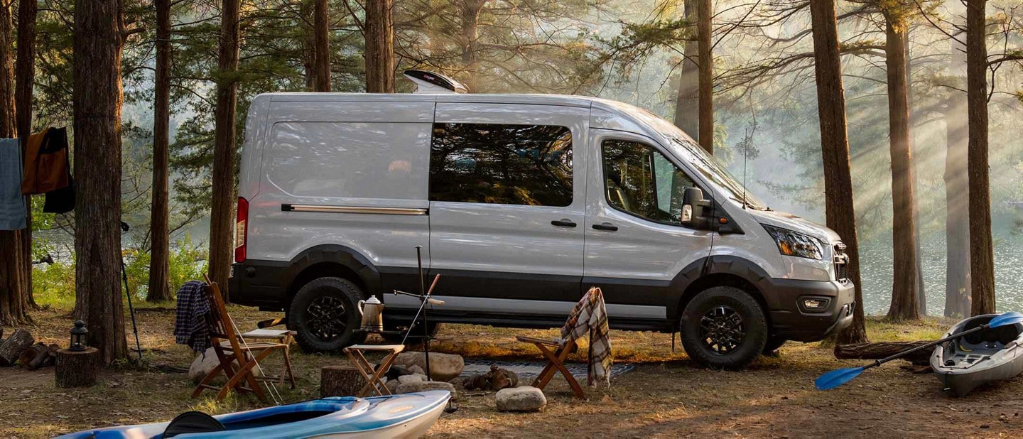 A 2023 Ford Transit Trail™ van parked in the woods