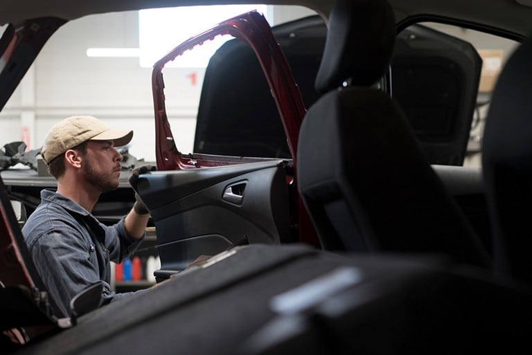 Ford technician fixing a door on a Ford vehicle