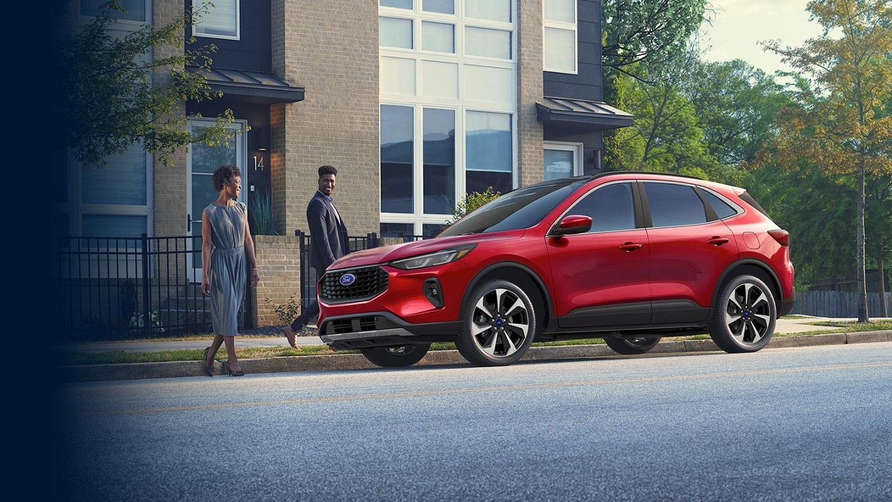 Two people approaching a 2024 Ford Escape® parked on a city street