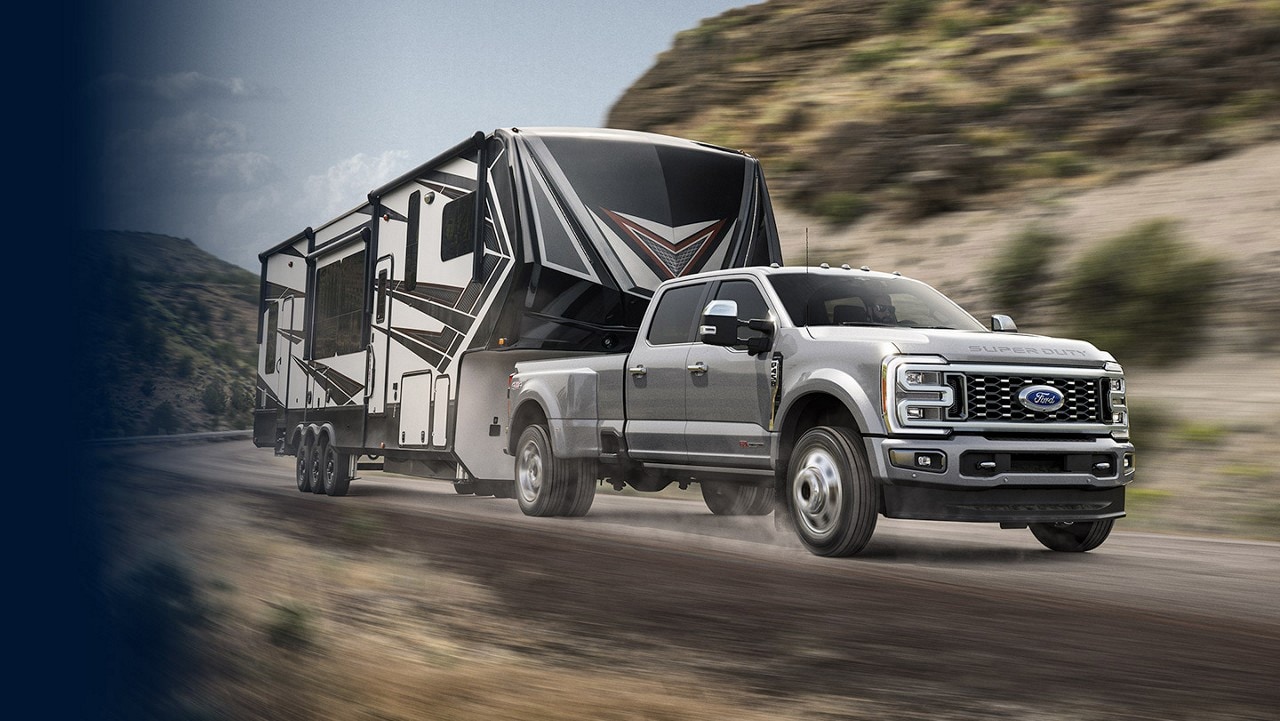 2024 Ford Super Duty® pulling an RV on a highway in the mountains