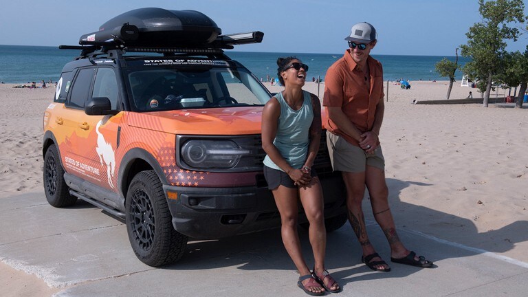 Man and woman leaning against a Bronco® Sport SUV